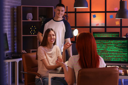 Team of young programmers working in office at night