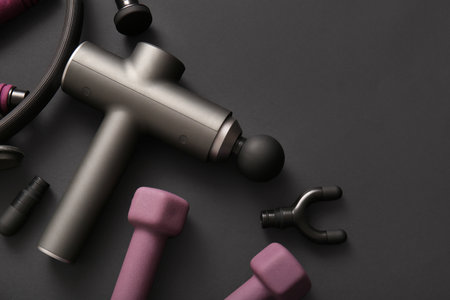 Percussive massager, nozzles and sports equipment on dark backgroundの写真素材