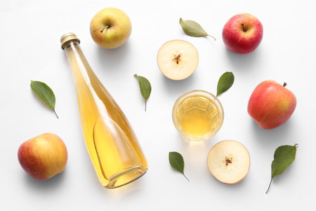 Composition with fruits, bottle and glass of fresh apple cider on white backgroundの写真素材
