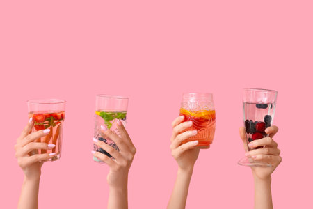 Many hands with infused water on pink backgroundの写真素材