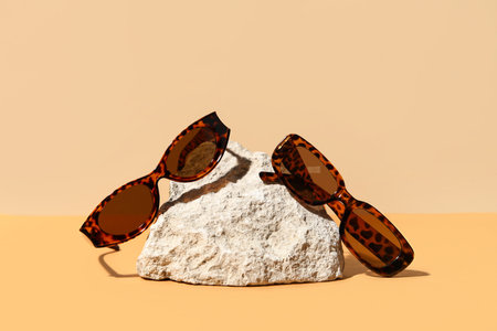 Stone with stylish sunglasses on colorful backgroundの写真素材