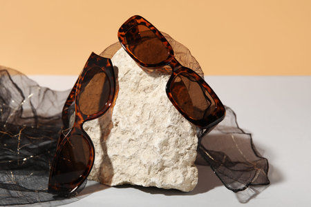 Stone with stylish sunglasses on colorful backgroundの写真素材