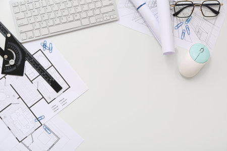 Frame made of architect's supplies with computer keyboard and house plans on white background