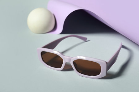 Decorative podium with stylish sunglasses on colorful backgroundの写真素材