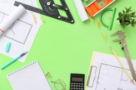 Frame made of architect's supplies with house plans on green background