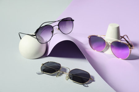Decorative podiums with different stylish sunglasses on colorful backgroundの写真素材