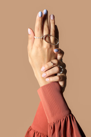 Female hands with beautiful manicure and stylish accessories against color background, closeupの写真素材
