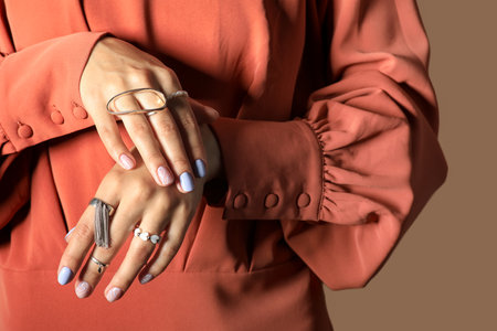 Young woman with beautiful manicure and stylish accessories on color background, closeupの写真素材