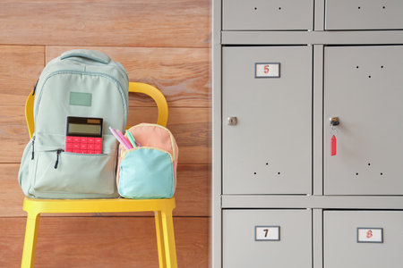 Locker with school backpacks near wooden wallの写真素材