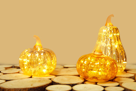 Glowing pumpkins on wooden table against green backgroundの写真素材
