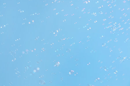 Beautiful soap bubbles floating on blue sky backgroundの写真素材