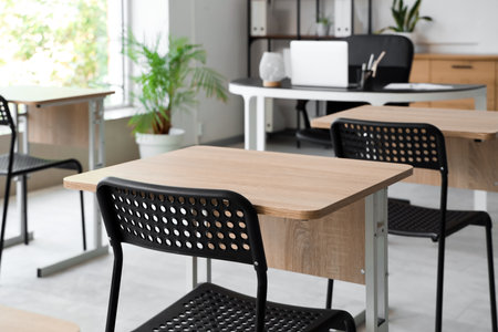 Desks and chairs in empty classroom at schoolの写真素材