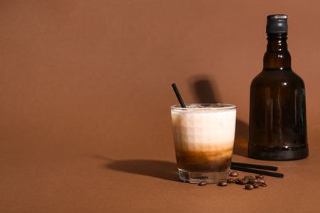 Glass of White Russian cocktail and coffee beans on brown backgroundの写真素材
