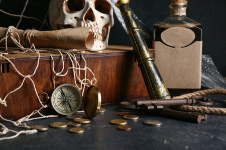 Spyglass with coins, compass and old keys on dark table, closeup. Pirate conceptの写真素材