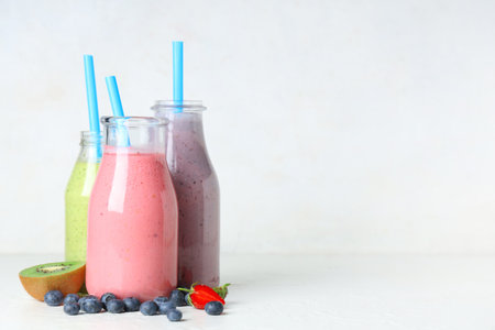 Bottles of fresh smoothie with different berries on white backgroundの写真素材