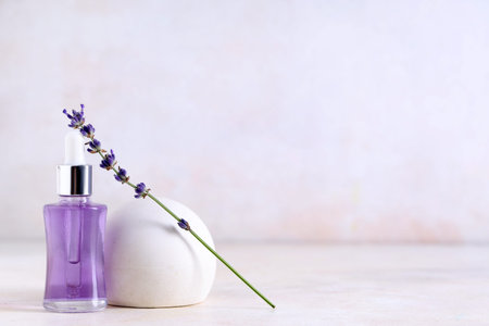 Plaster stand, bottle and bowl of lavender essential oil on light background, closeupの写真素材