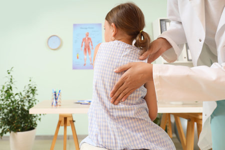 Female osteopath working with little patient in clinic, back viewの写真素材