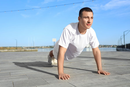 Sporty young man exercising at waterfront promenade