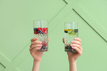 Hands with infused water on green backgroundの写真素材