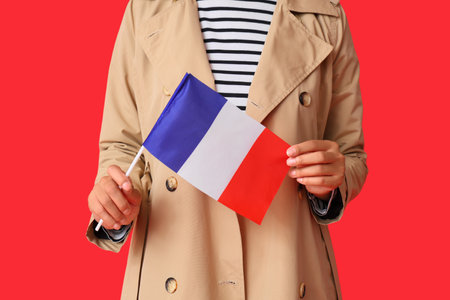 Beautiful young African-American woman with flag of France on red background, closeupの写真素材