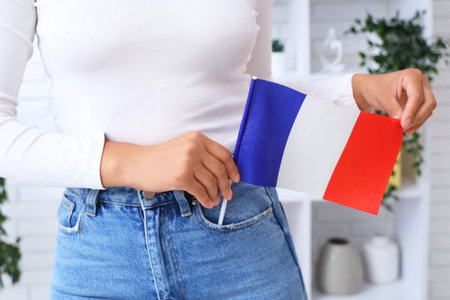 Beautiful young African-American woman with flag of France at home, closeupの写真素材