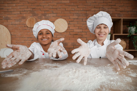 Teenage chefs playing with hands covered in flour at homeの写真素材