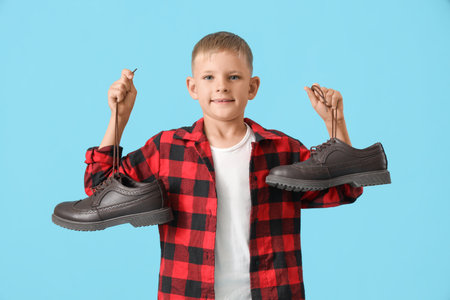 Cute little happy boy with clean shoes on blue backgroundの写真素材