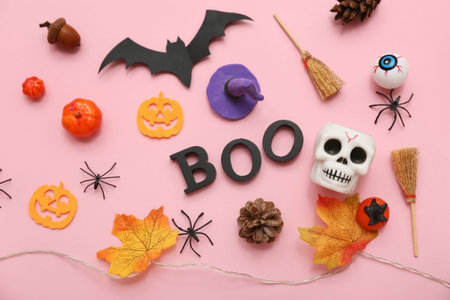 Composition with word BOO and different decorations for Halloween on pink background