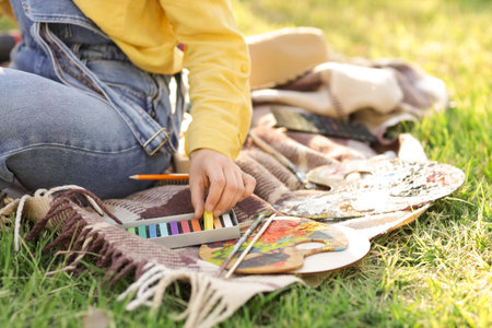 Female artist with chalks in park, closeup