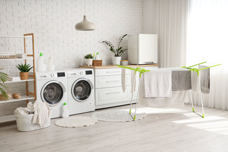 Interior of laundry room with dryer and washing machinesの写真素材