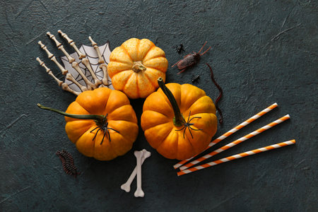 Halloween composition with fresh pumpkins and decorations on dark color backgroundの写真素材