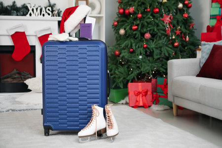 Suitcase with Santa hat, passport and ice skates in living roomの写真素材