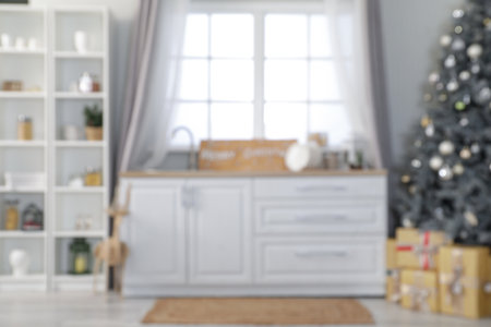 Blurred view of light kitchen with Christmas tree, counters and shelf unitの写真素材