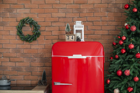 Cube calendar with Christmas lantern and decor on refrigerator in kitchenの写真素材