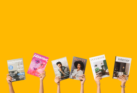 Female hands with different magazines on yellow backgroundの写真素材