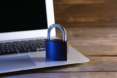 Laptop with padlock on wooden table, closeup. Cyber security conceptの写真素材