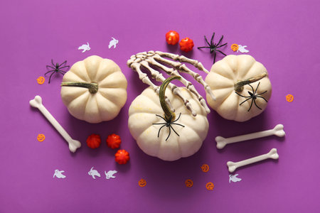 Composition with fresh pumpkins and decorations for Halloween on purple backgroundの写真素材