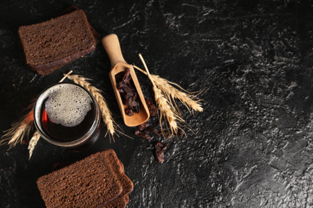 Glass of fresh kvass with slices of bread and wheat on black backgroundの写真素材
