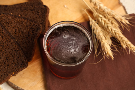 Glass of fresh kvass with slices of bread and wheat on white background, closeupの写真素材