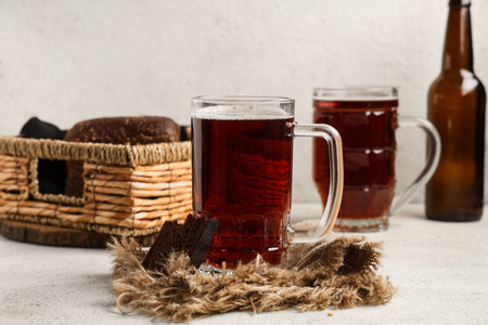Glasses of fresh kvass and slice of bread on white backgroundの写真素材