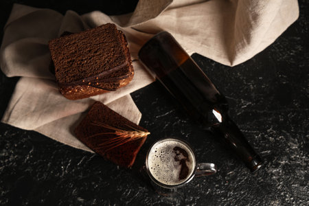 Glass of fresh kvass with slices of bread and wheat on black backgroundの写真素材