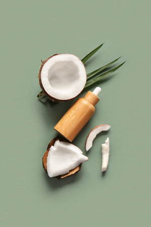 Bottle of coconut cosmetic oil and palm leaves on green backgroundの写真素材