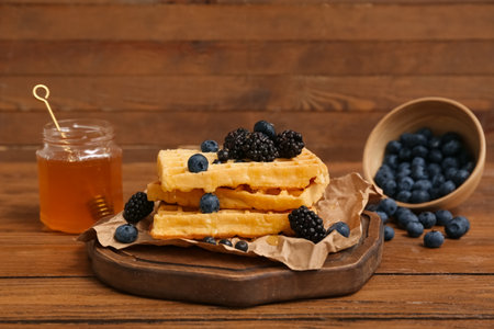 Board of sweet Belgian waffles with fresh blueberries, blackberries and mint on wooden backgroundの写真素材