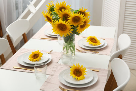Table setting with sunflowers in dining roomの写真素材