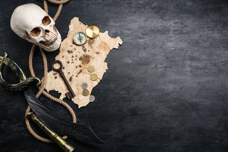 Skull with compass, old key and sword on dark background. Pirate conceptの写真素材