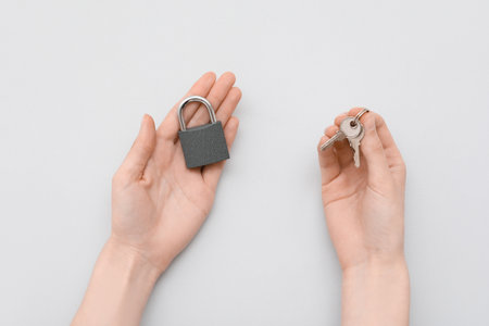 Hands with padlock and key on gray backgroundの写真素材