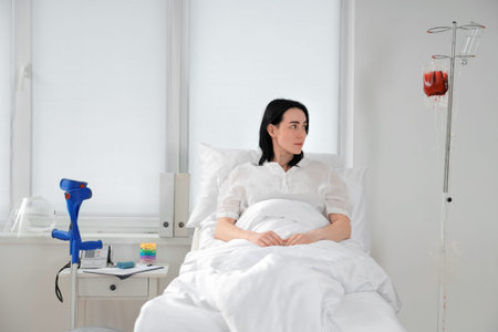 Female patient lying on bed in hospital ward
