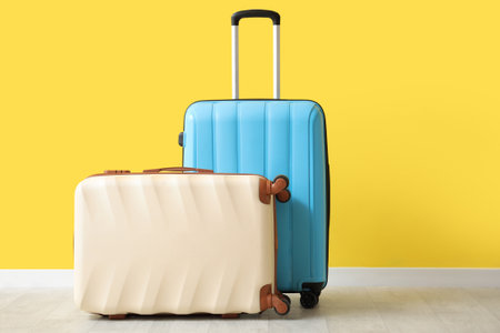 Packed suitcases near yellow wallの写真素材