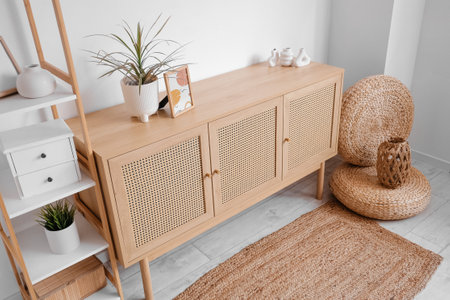 Wooden chest of drawers and wicker decor in interior of living roomの写真素材