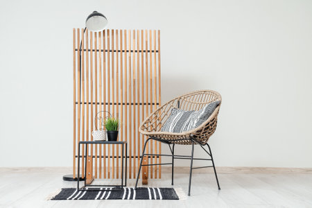 Stylish interior of living room with comfortable armchair, coffee table, lamp and folding screenの写真素材